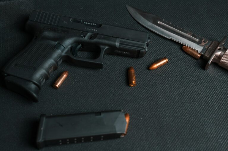 black semi automatic pistol beside brown and silver pocket knife